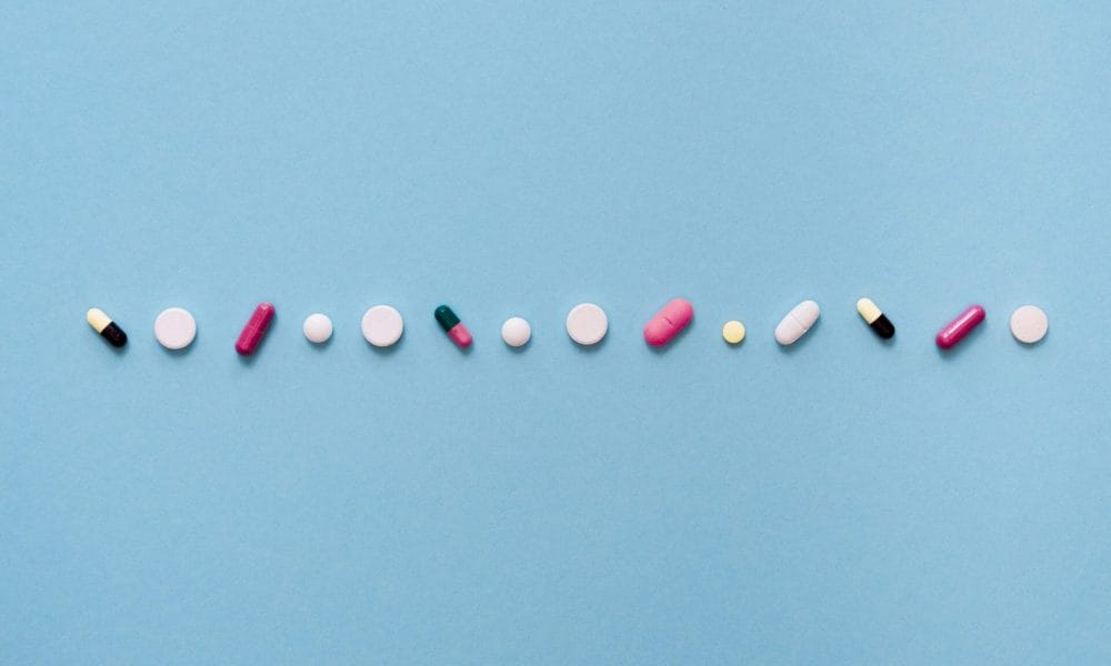 conjunto de pastillas de distinto tipo y color sobre fondo azul