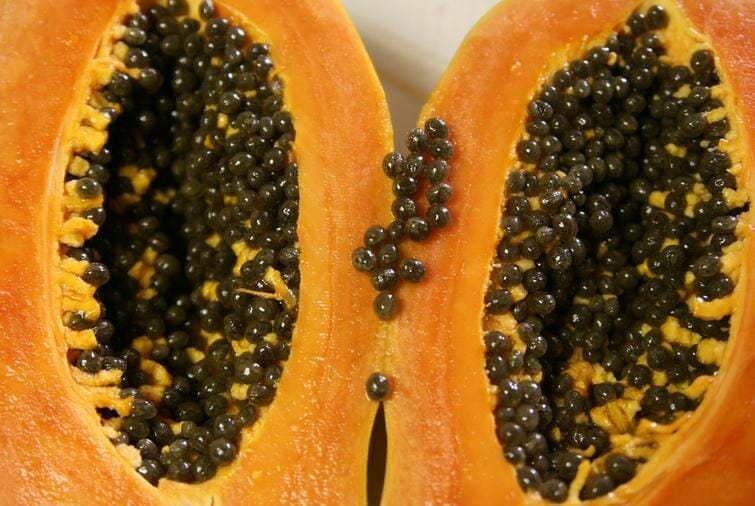 papaya abierta por en centro mostrando ambas caras por su interior